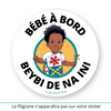 Ce sticker illustre un petit garçon noir avec des cheveux bouclés et volumineux (cheveux afro enfant). Il porte un t-shirt blanc avec une grande fleur rouge , avec d’un pagne coloré en bleu, jaune et rouge noué sur son épaule gauche. Le texte "Bébé à Bord" est affiché en haut, tandis que "Beybi De Na Ini", en langue bushinengué (Ndjuka / Aluku -  langue de la famille des créoles à base lexicale anglaise parlé au Suriname et dans l'ouest de la Guyane française), est inscrit en bas en noir.