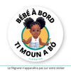Ce sticker rond représente une illustration d’une petite fille noire avec des cheveux afro coiffés en deux chignons volumineux et des tresses décoratives (cheveux crépus type 4a, 4b ou 4c - ou alors 3a, 3b ou 3c). Elle porte une robe blanche à rayures bleues avec un petit cœur rouge sur le devant. Dans sa main droite, elle tient un moulin à vent multicolore. Le texte "Bébé à bord" est affiché en haut, et "Ti Moun A Bò", en créole Antillais Guyanais, est inscrit en bas en noir. 