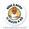 Ce sticker rond affiche une illustration vibrante d’une petite fille noire portant un t-shirt blanc orné d’illustrations tropicales comprenant des fleurs rouges et jaunes ainsi qu’un colibri vert. Elle porte un foulard madras aux tons jaunes (maré tèt madras créole), rouges et verts, qui met en valeur ses traits. Elle tient un moulin à vent multicolore dans sa main droite. Le texte "Bébé à bord" est placé en haut, tandis que "Ti Moun A Bò", en créole Antillais Guyanais,  est inscrit en bas en noir