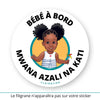 Ce sticker rond illustre une petite fille noire avec des cheveux coiffés en deux chignons volumineux et ornés de tresses décoratives (cheveux crépus type 4a, 4b ou 4c - ou alors 3a, 3b ou 3c). Elle porte une robe blanche à rayures bleues avec un petit cœur rouge sur le devant. Dans sa main droite, elle tient un moulin à vent multicolore. Le texte "Bébé à Bord" est affiché en haut, tandis que "Mwana Na Kati", traduction en lingala qui est une langue bantoue parlée en république démocratique du Congo.