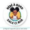 Ce sticker rond illustre une petite fille noire avec des cheveux coiffés en deux chignons volumineux, agrémentés de tresses décoratives (cheveux crépus type 4a, 4b ou 4c - ou alors 3a, 3b ou 3c). Elle porte une robe blanche à rayures bleues avec un petit cœur rouge sur le devant. Dans sa main droite, elle tient un moulin à vent multicolore. Le texte "Bébé à Bord" est inscrit en haut, tandis que "Xale Ci Biir" , en wolof (langue notamment parlée au Sénégal et en Mauritanie), apparaît en bas en noir.